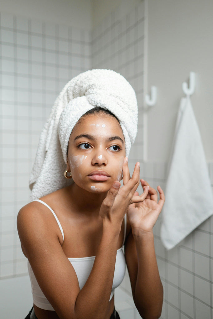 Woman applying skincare in the mirror