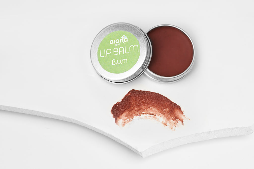 Lip balm tin with a spoonful of coffee, coral brown lip balm on a white background