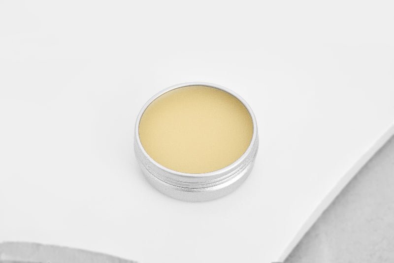 Balm in a silver container on a white background