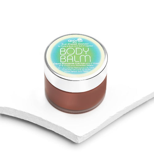 Jar of body balm with a white lid on a white background