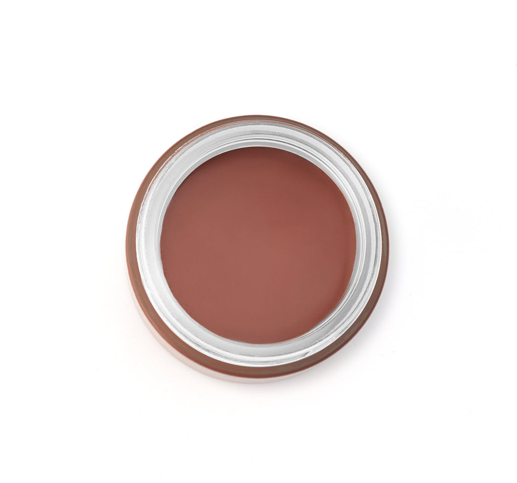 Tinted bronzer with sunscreen in a round container on a white background