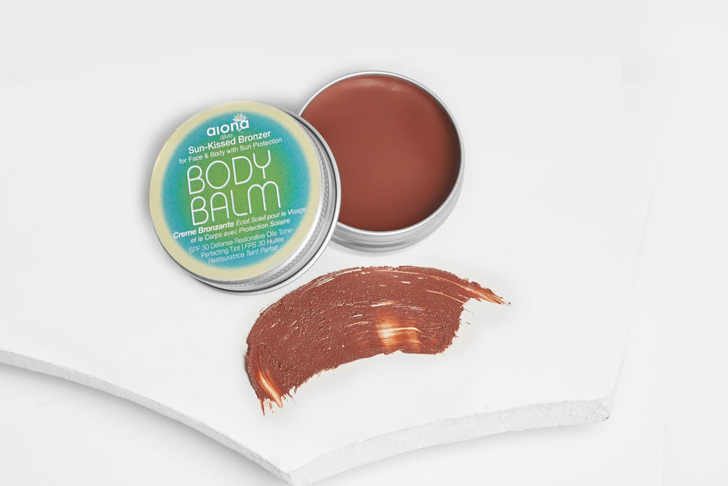 Body balm with open lid and swatch on a white background