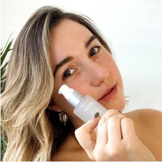 girl_using_serum bottle next to her face